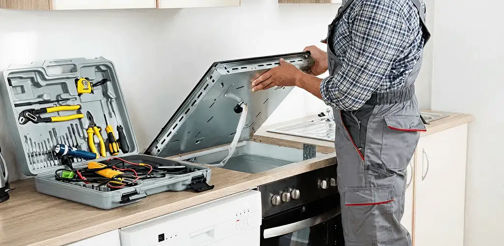 Handyman repairing a cooktop and checking wiring connections in Tacoma, WA