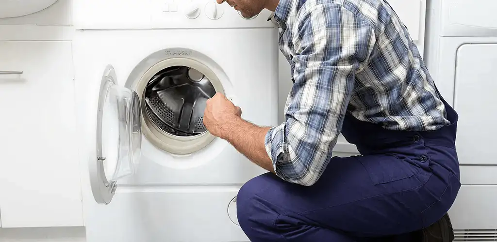 Handyman inspecting a dryer drum and internal parts for repair in Tacoma, WA