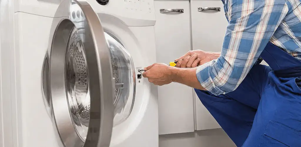 Handyman repairing a clothes dryer and checking electrical connections in Tacoma, WA