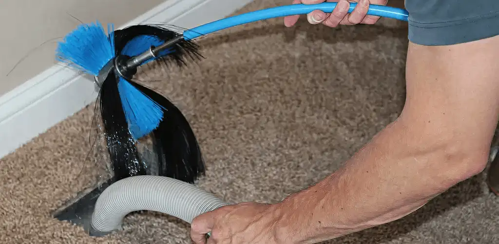 Dryer vent cleaning technician brushing lint from a vent line in Tacoma, WA
