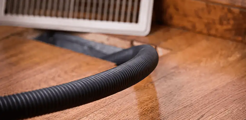 Air duct cleaning hose inserted into a floor vent for ductwork cleaning in Tacoma, WA